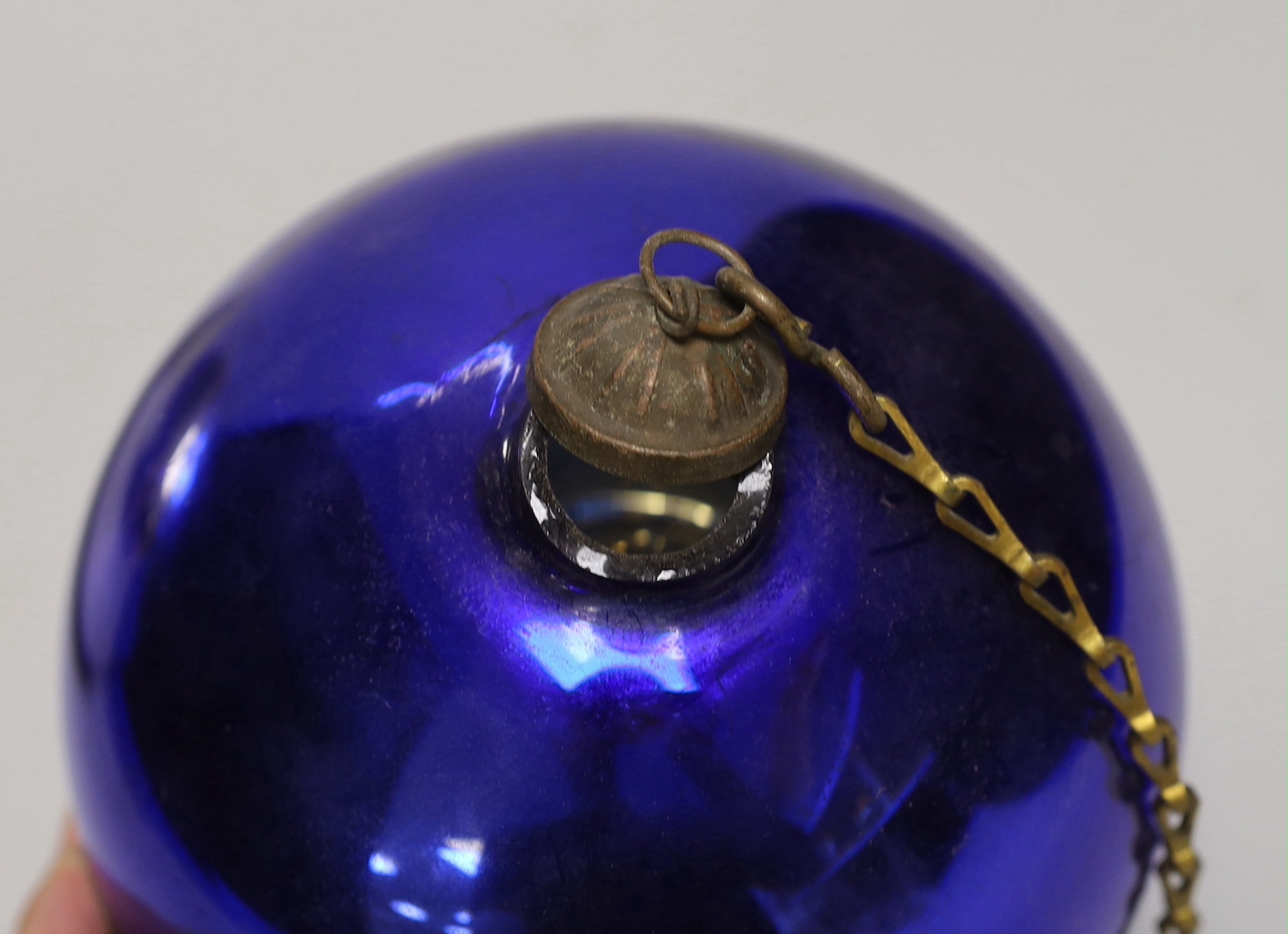 A Victorian silvered witch's ball and a smaller blue glass witch’s ball, the largest approximately 26cm in diameter